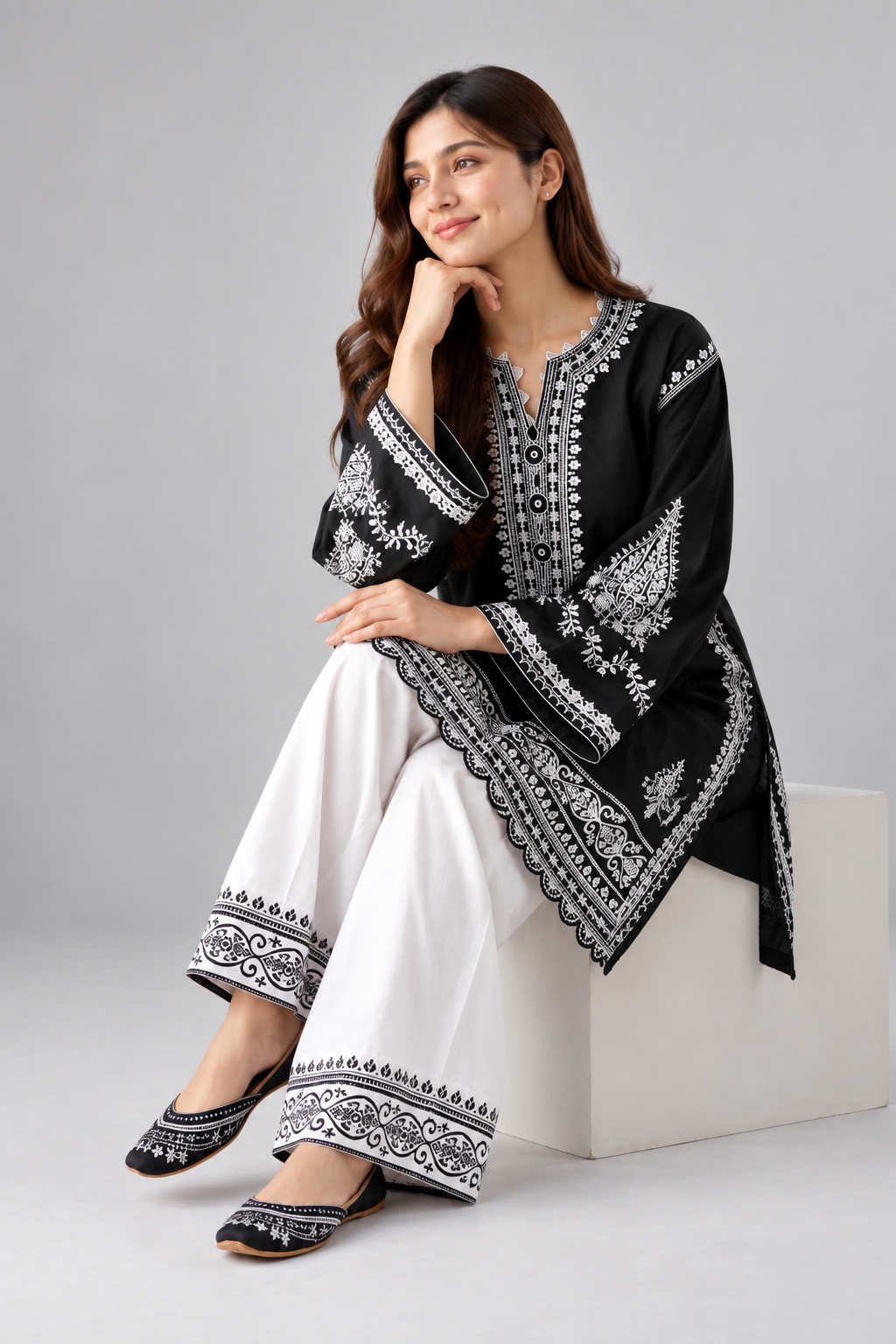 Black embroidered kurta with white wide-leg trousers.