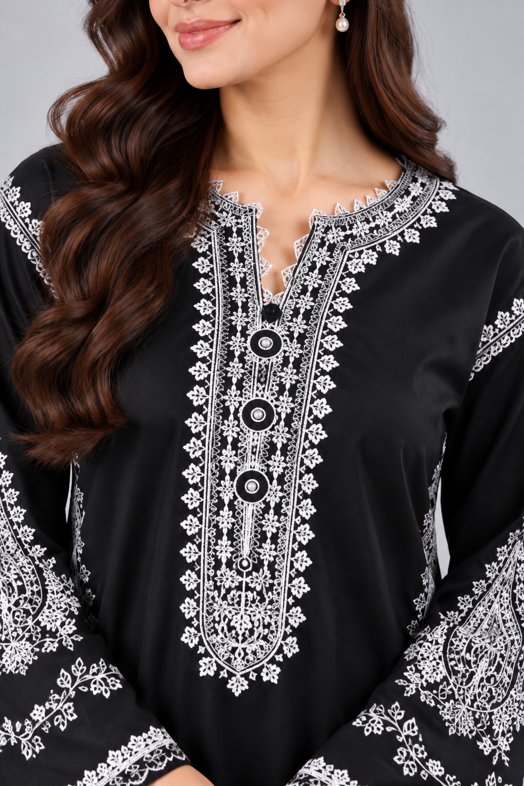 Close-up of white floral embroidery on black kurta.